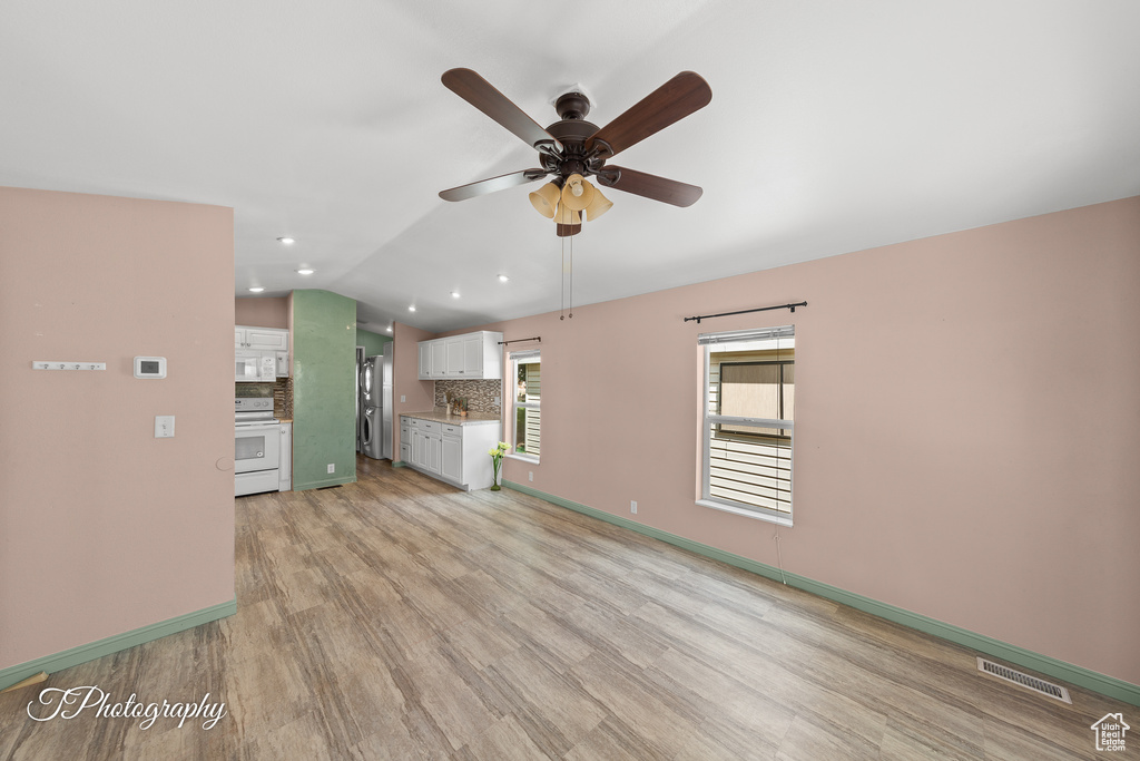 Unfurnished living room featuring ceiling fan, vaulted ceiling, light wood finished floors, and recessed lighting
