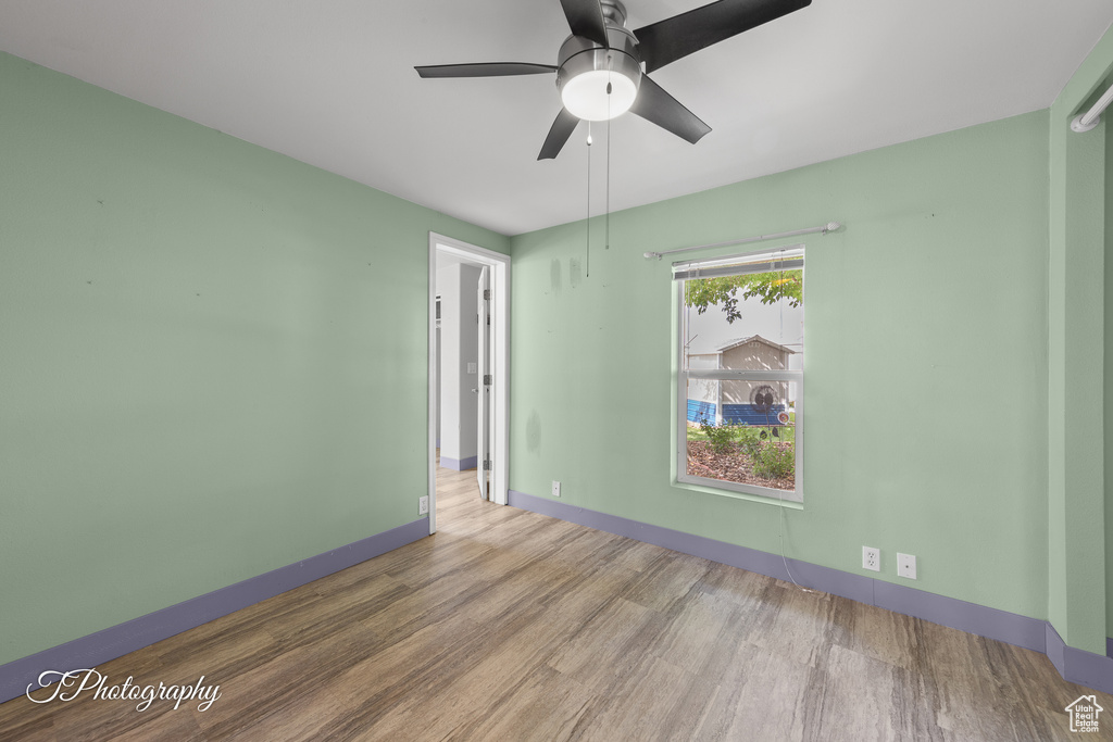 Empty room with wood finished floors and ceiling fan