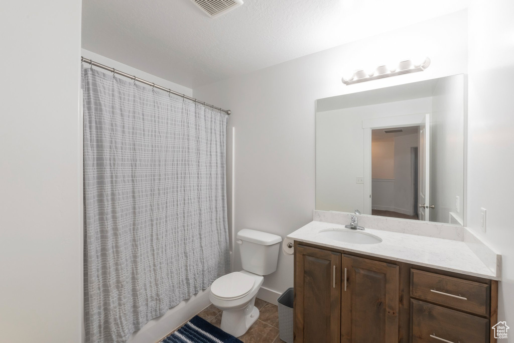 Full bathroom featuring vanity, shower / bath combination with curtain, and tile patterned flooring