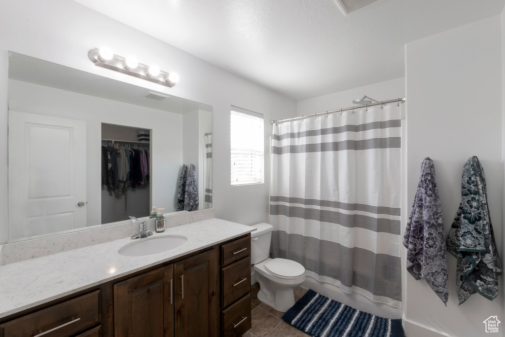 Bathroom featuring vanity, tile patterned floors, a shower with shower curtain, and a spacious closet