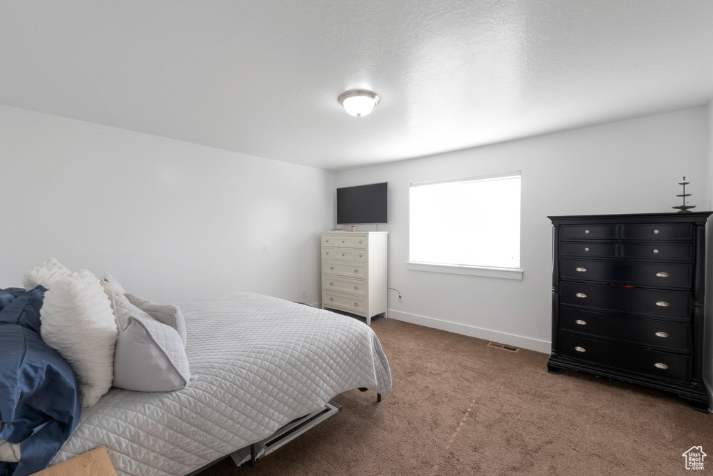 Bedroom featuring carpet floors and baseboards