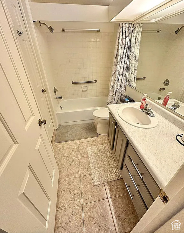 Bathroom with shower / bath combo with shower curtain, vanity, and tile patterned flooring