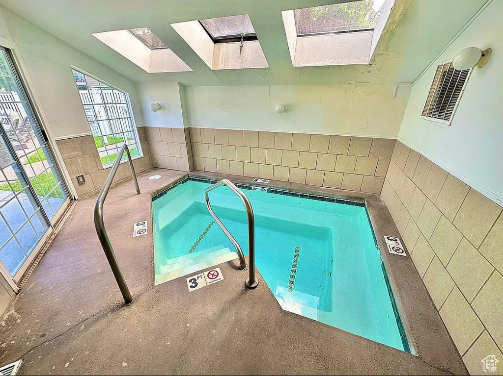 View of swimming pool featuring a skylight and a pool