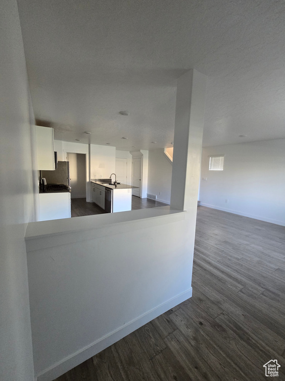 Kitchen with open floor plan, dark wood finished floors, white cabinets, and freestanding refrigerator