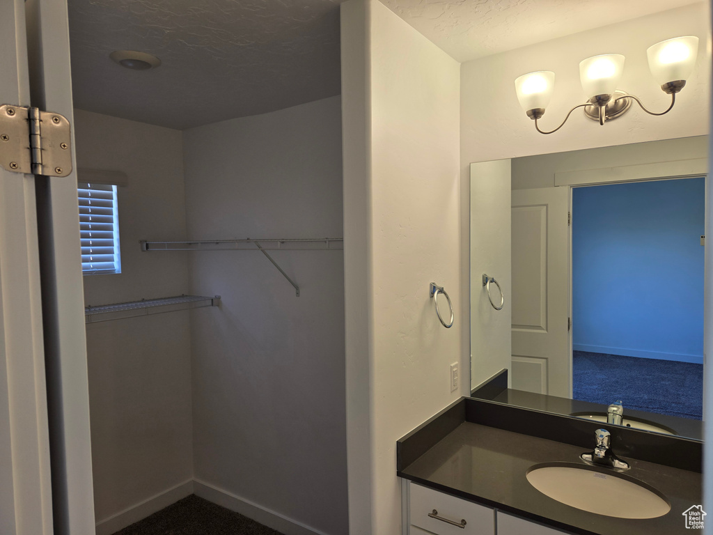 Bathroom featuring vanity and a spacious closet