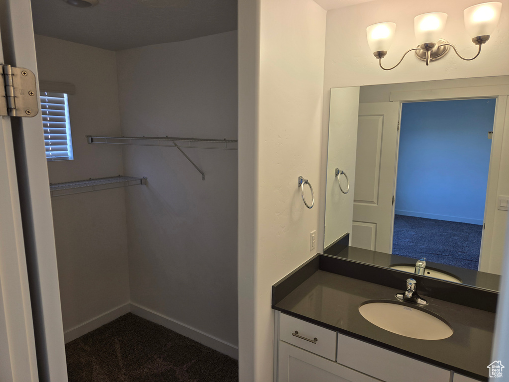 Bathroom with vanity and a walk in closet