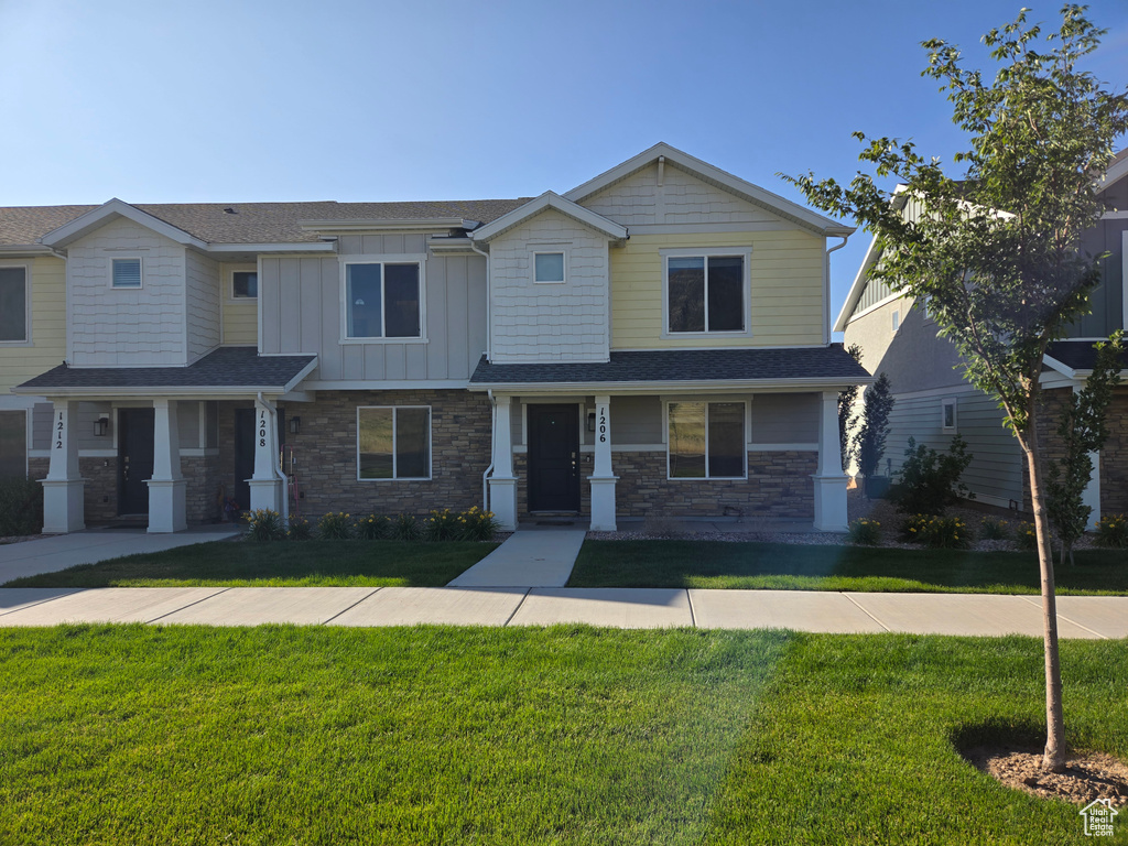 Craftsman inspired home with a front lawn, stone siding, and board and batten siding