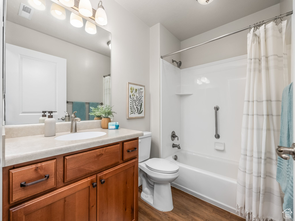 Full bathroom featuring vanity, wood finished floors, and shower / bath combo
