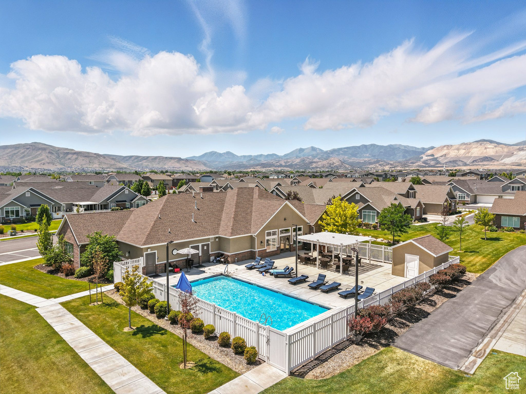 View of swimming pool with a residential view, a fenced backyard, and a mountain view