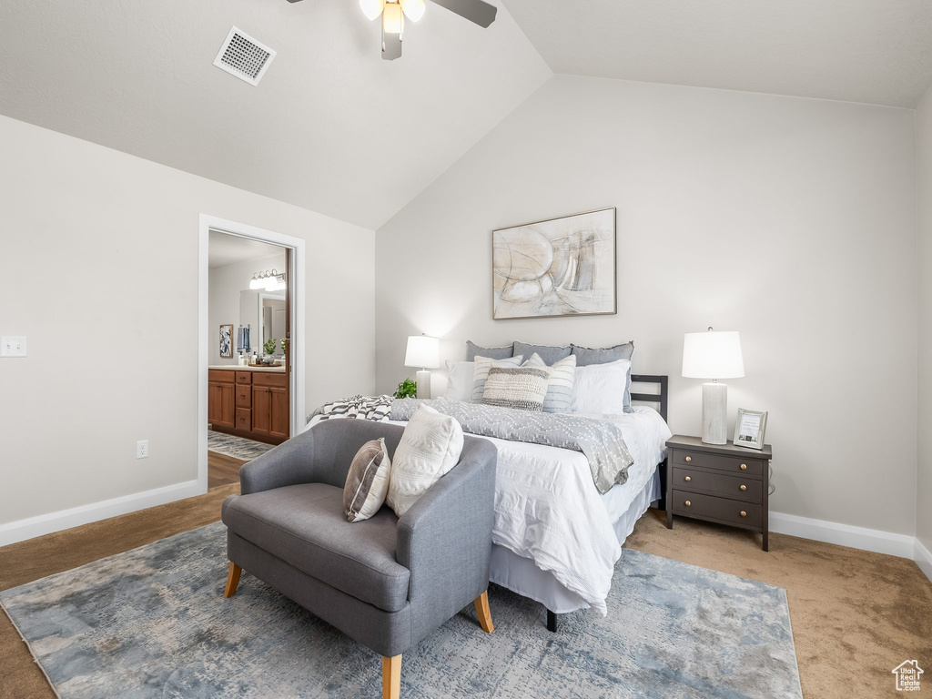Bedroom featuring vaulted ceiling, carpet floors, ensuite bathroom, and a ceiling fan