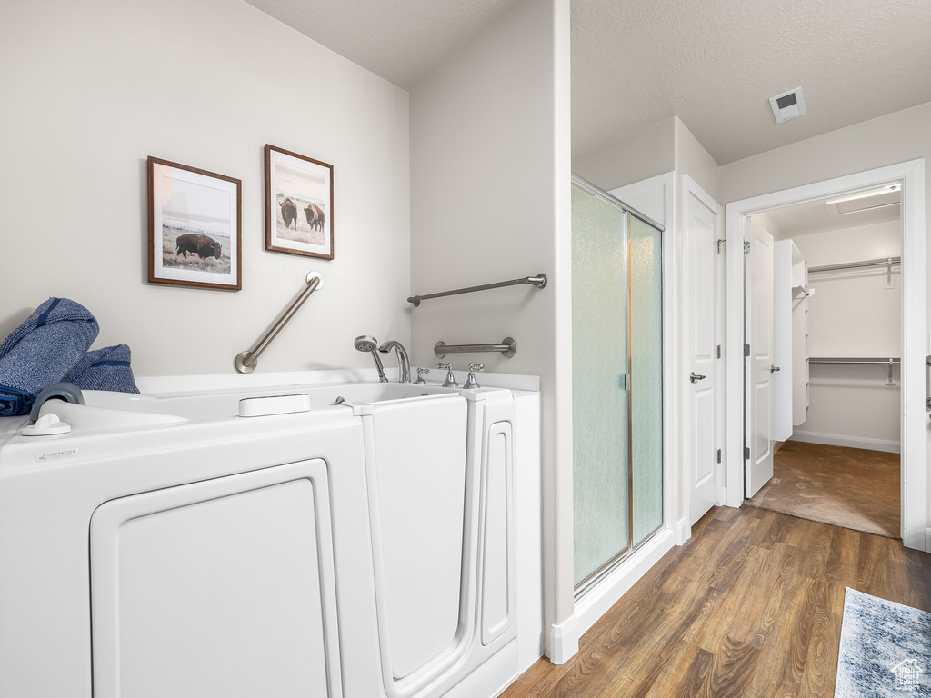 Laundry area featuring washer / clothes dryer and wood finished floors