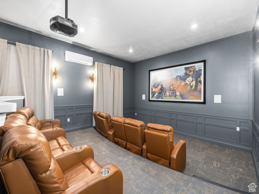 Carpeted home theater room with a decorative wall, an AC wall unit, a wainscoted wall, and recessed lighting