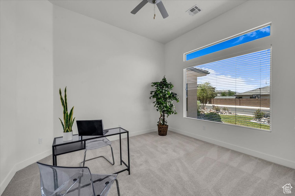 Carpeted home office with ceiling fan and baseboards