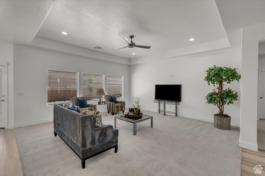 Living area featuring ceiling fan, recessed lighting, and a raised ceiling
