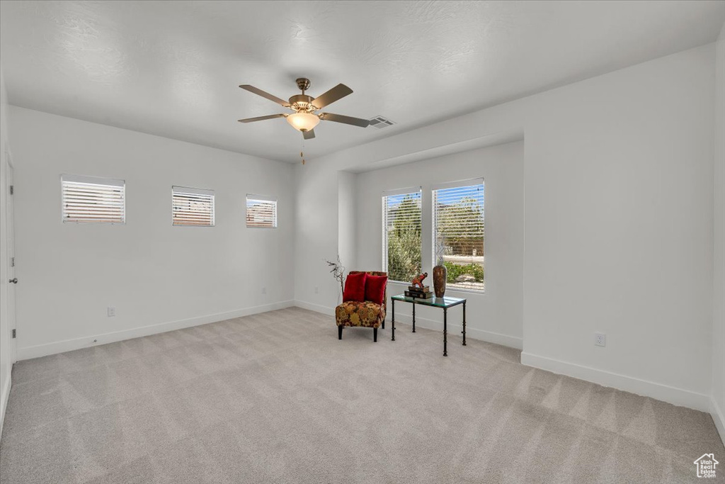 Sitting room featuring light carpet and a ceiling fan