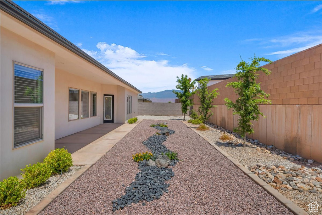 Fenced backyard featuring a mountain view and a patio