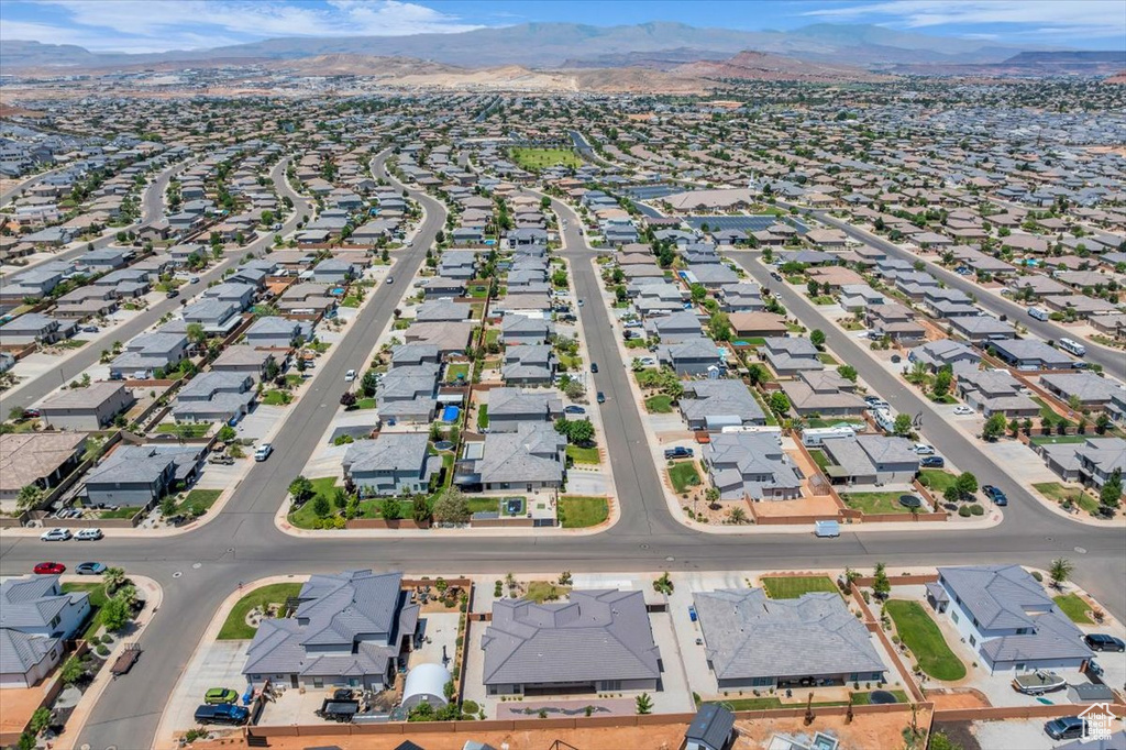Aerial overview of property's location with nearby suburban area and a mountainous background