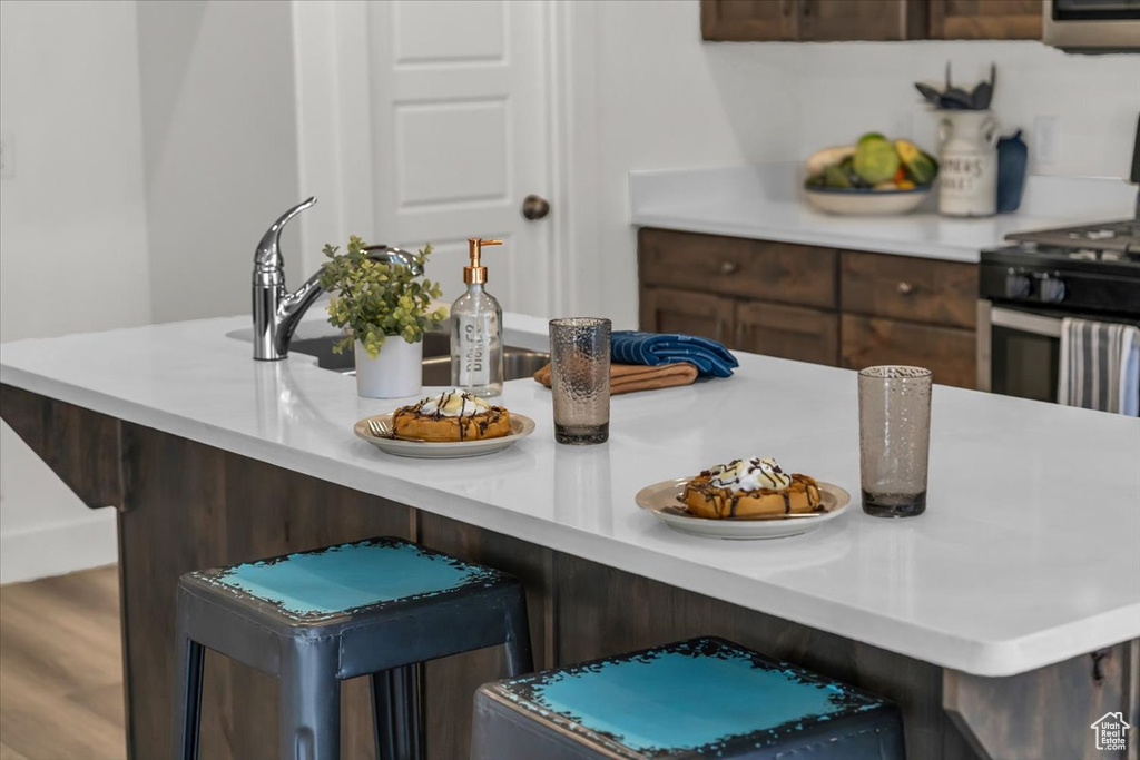 Kitchen featuring stainless steel gas range and light countertops