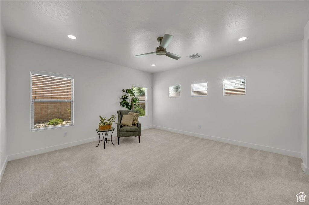 Sitting room featuring plenty of natural light, ceiling fan, light colored carpet, and recessed lighting
