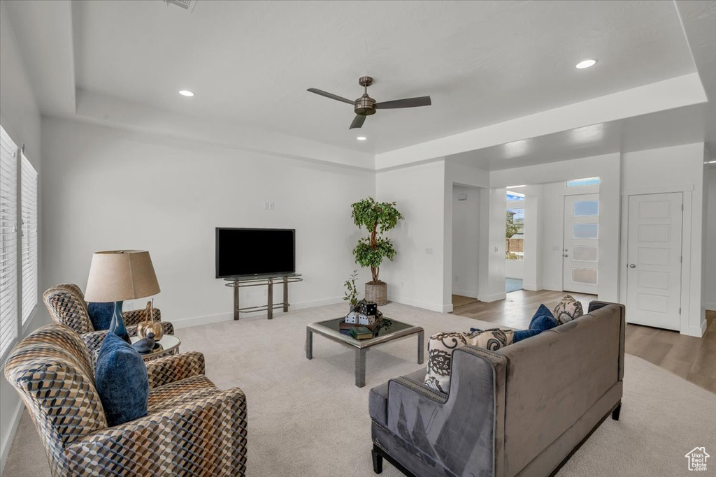 Living room with a tray ceiling, a ceiling fan, recessed lighting, and carpet
