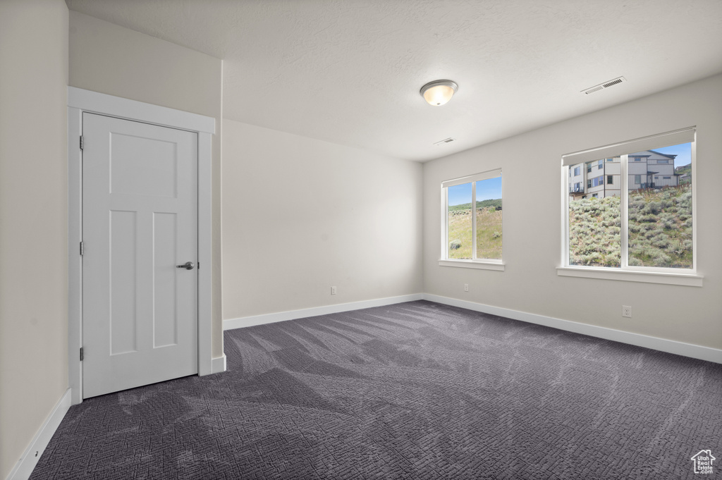 Unfurnished room with dark carpet