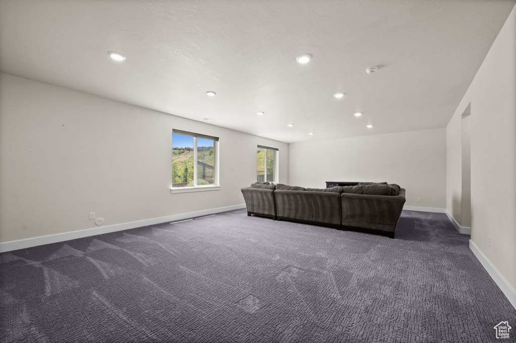 Living area featuring recessed lighting and dark colored carpet