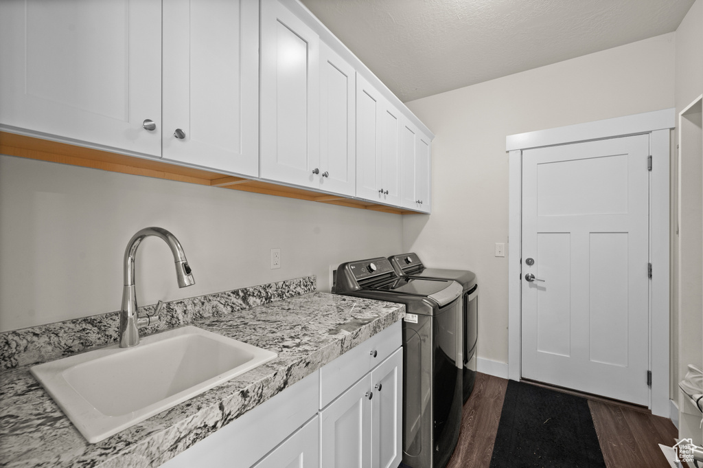 Washroom featuring cabinet space, separate washer and dryer, and dark wood-style flooring