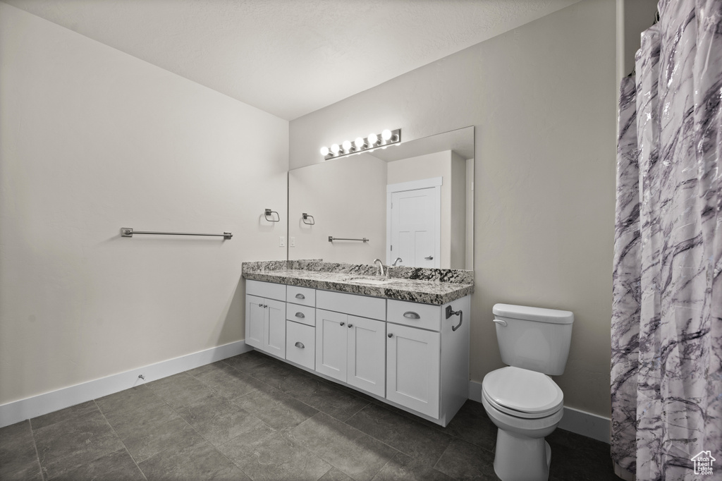 Full bath featuring vanity and baseboards