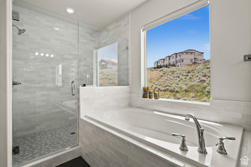 Full bath with a bath, a shower stall, plenty of natural light, and recessed lighting