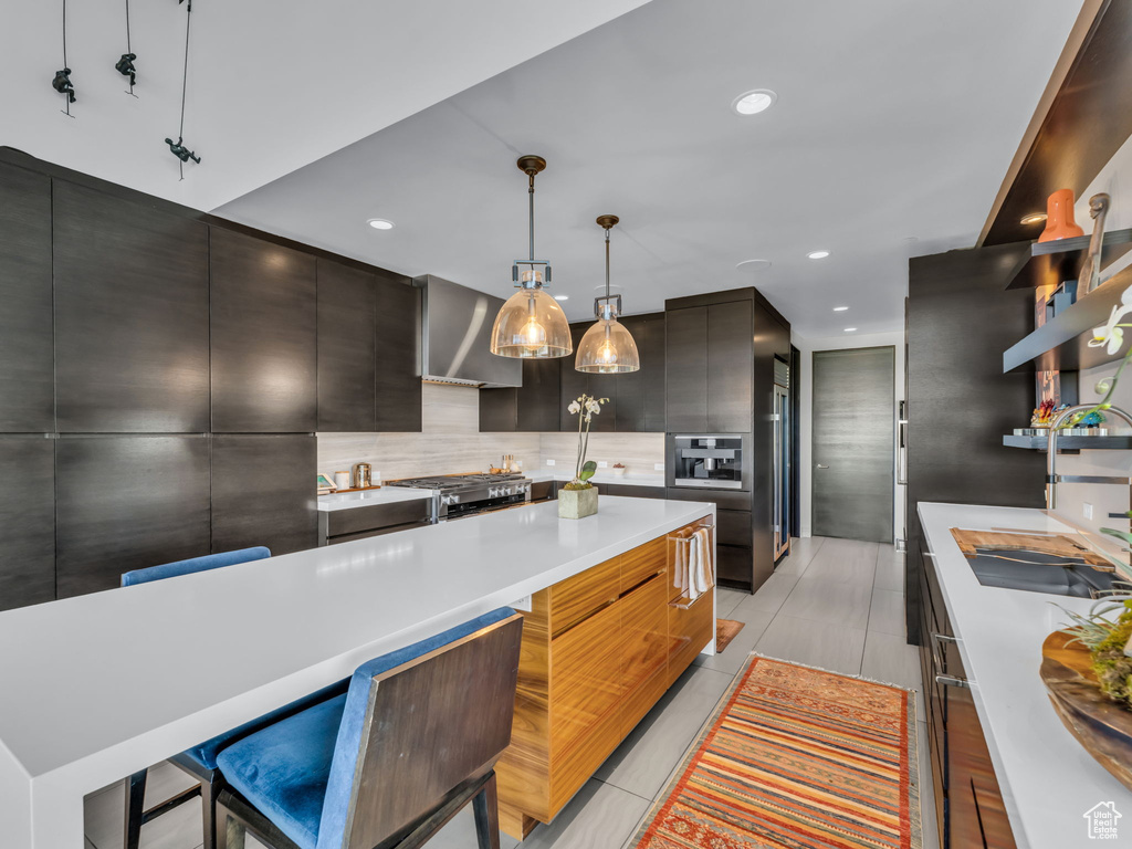 Kitchen with modern cabinets, light countertops, tasteful backsplash, recessed lighting, and stove