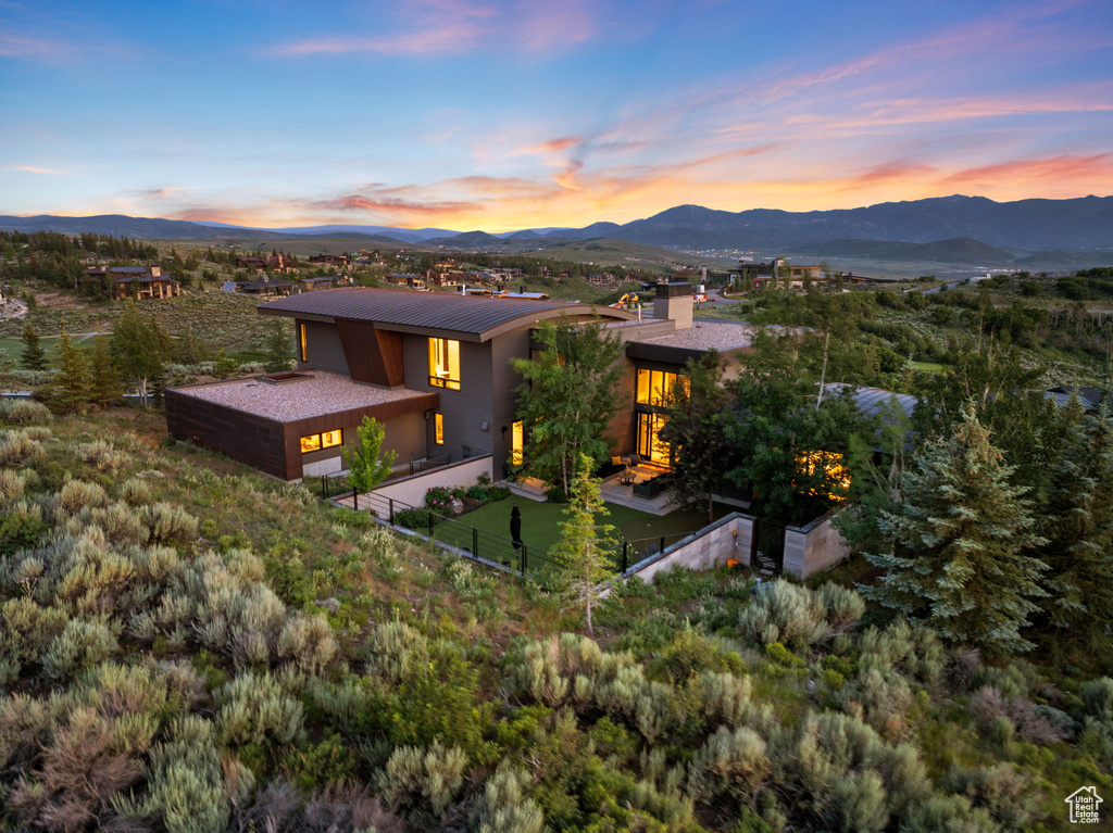 View of front of house featuring a mountain view, a metal roof, and stucco siding