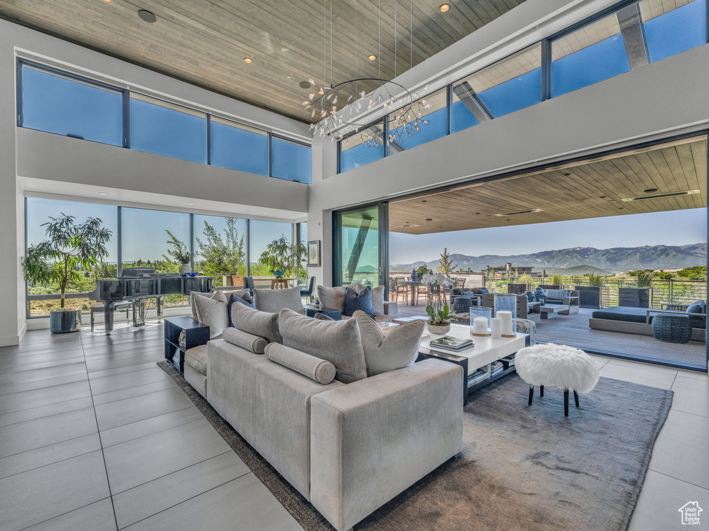Tiled living area with wooden ceiling, a towering ceiling, a mountain view, recessed lighting, and a chandelier