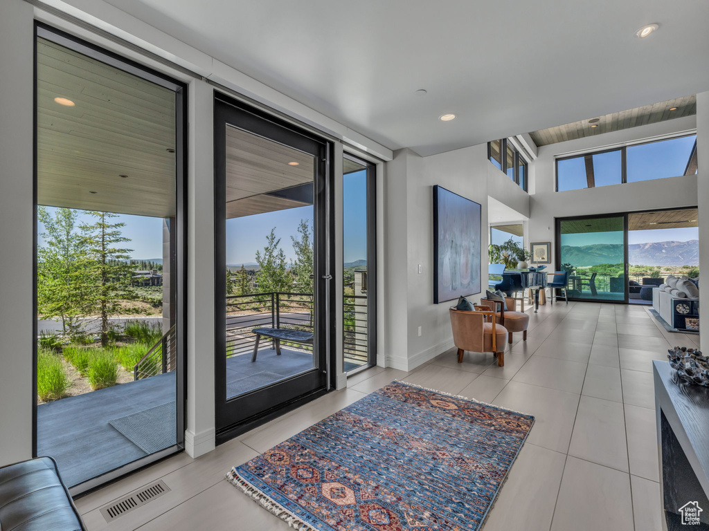 Doorway to outside featuring tile patterned flooring and recessed lighting