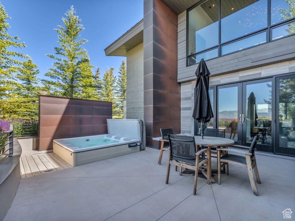 View of patio / terrace featuring a covered hot tub, outdoor dining space, and french doors