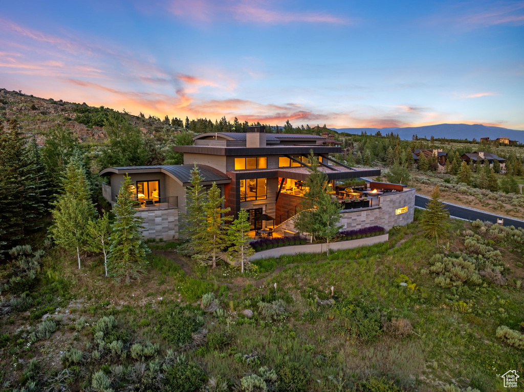 Rear view of house with solar panels, a mountain view, and stucco siding