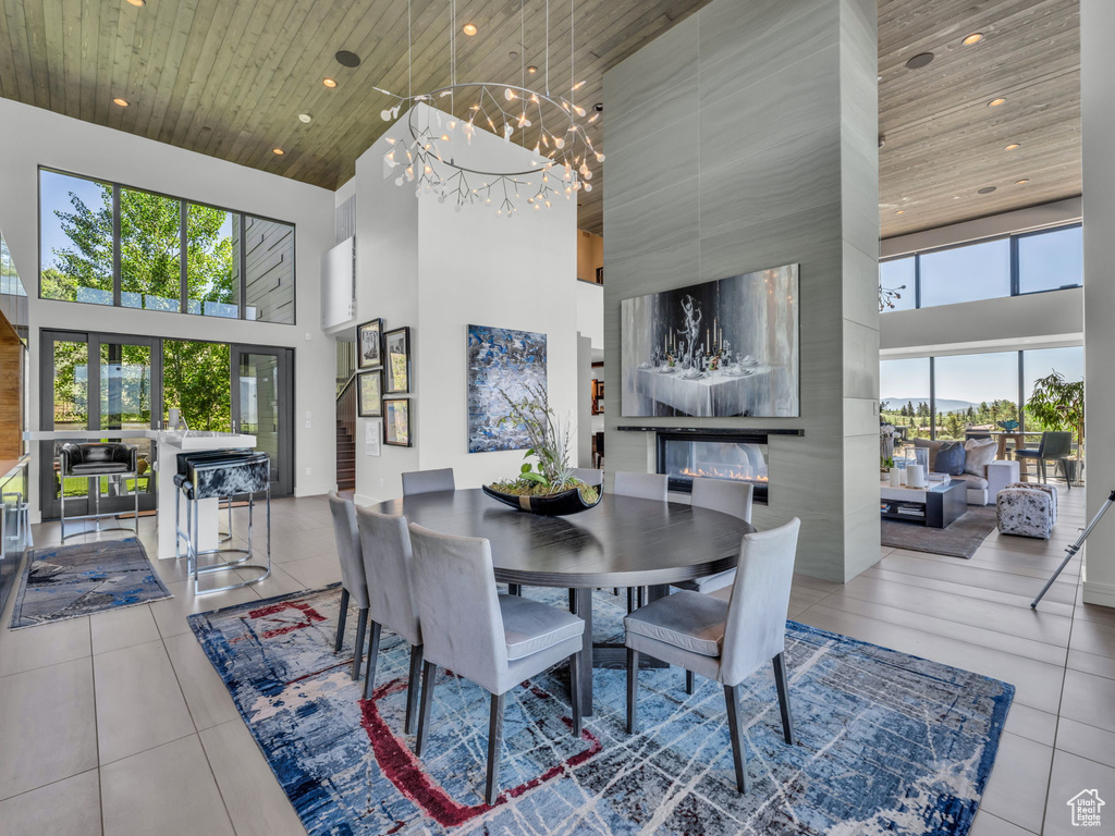 Dining room featuring a towering ceiling, wooden ceiling, tile patterned floors, a chandelier, and recessed lighting