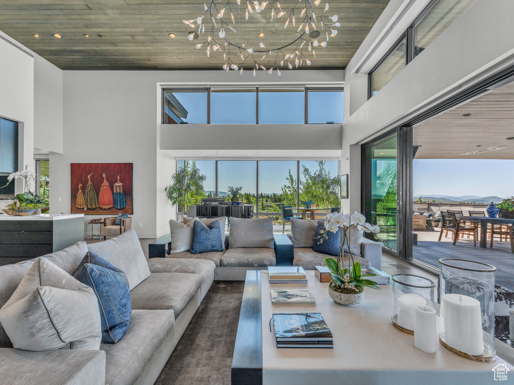 Living area with a high ceiling, a chandelier, and wood ceiling