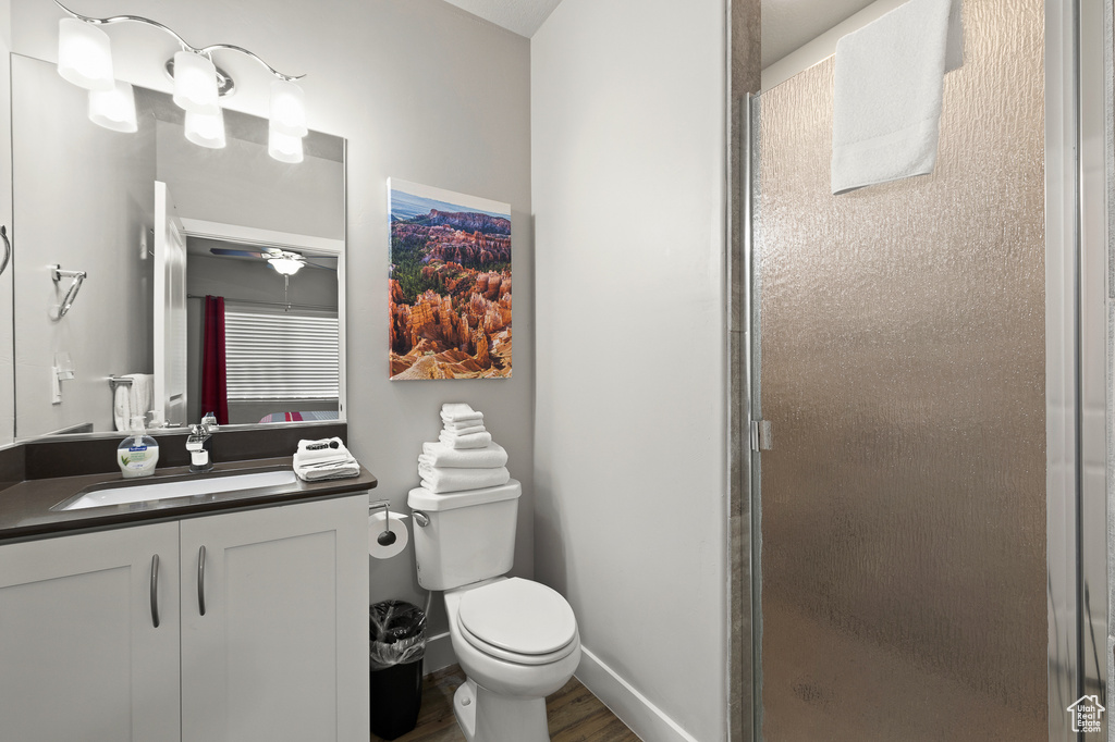 Bathroom featuring vanity, a stall shower, wood finished floors, and ceiling fan