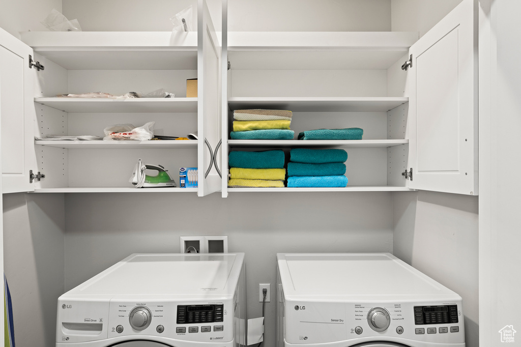 Laundry room with washer and clothes dryer and cabinet space