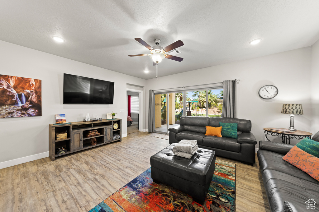 Living room featuring a ceiling fan, wood finished floors, and recessed lighting