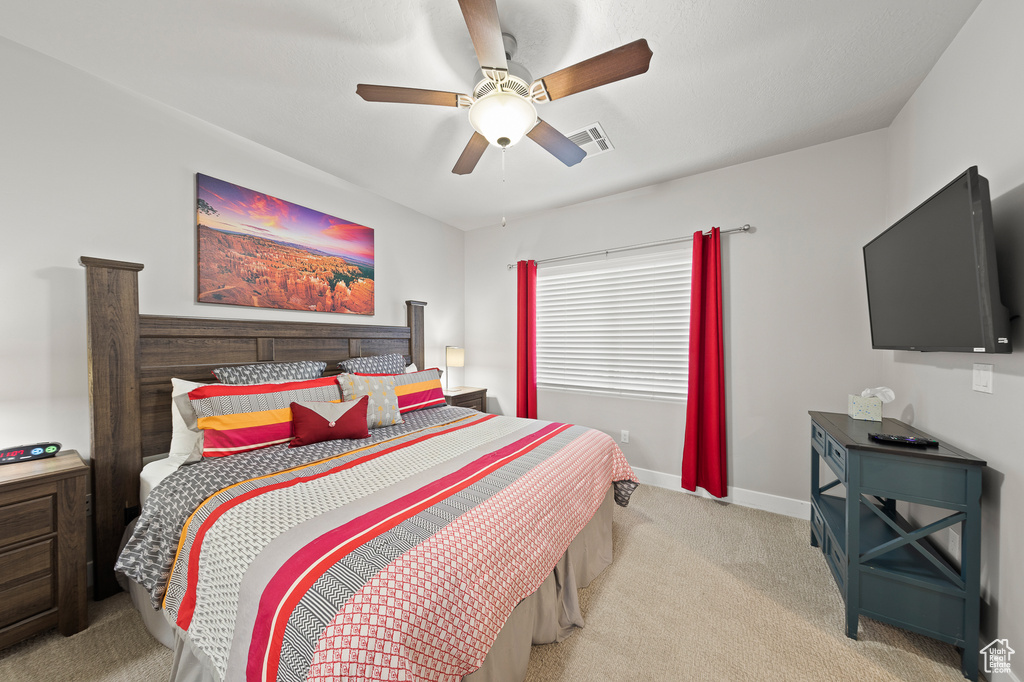 Carpeted bedroom with ceiling fan and baseboards
