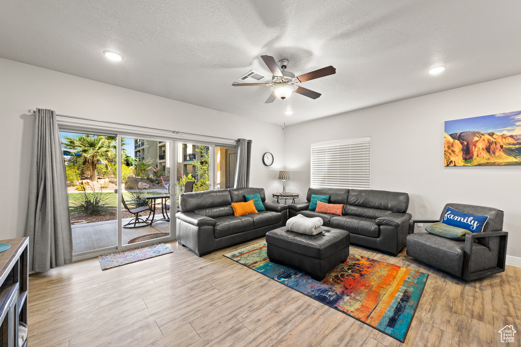 Living area featuring wood finished floors, ceiling fan, a textured ceiling, and recessed lighting