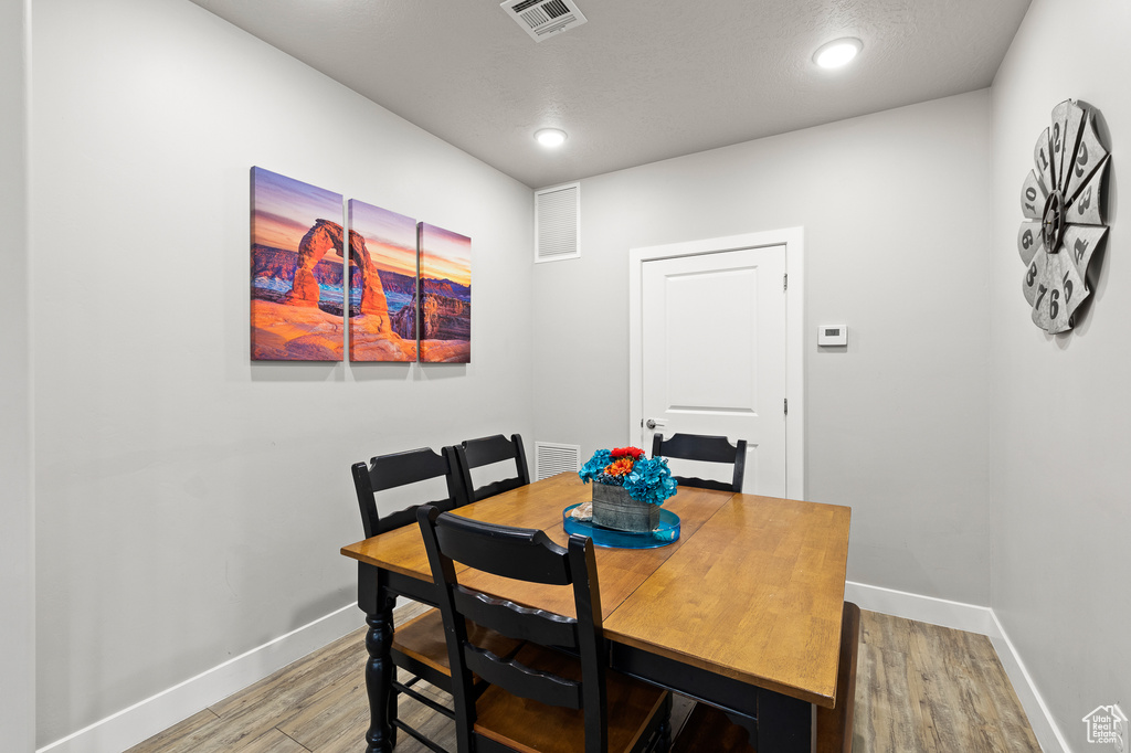 Dining room with wood finished floors and recessed lighting