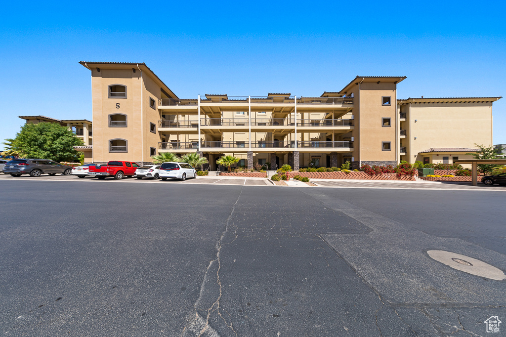 View of apartment building / complex featuring uncovered parking