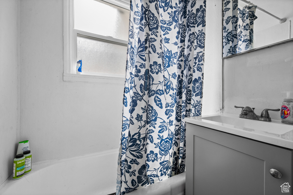 Full bath featuring vanity and shower / bath combination with curtain