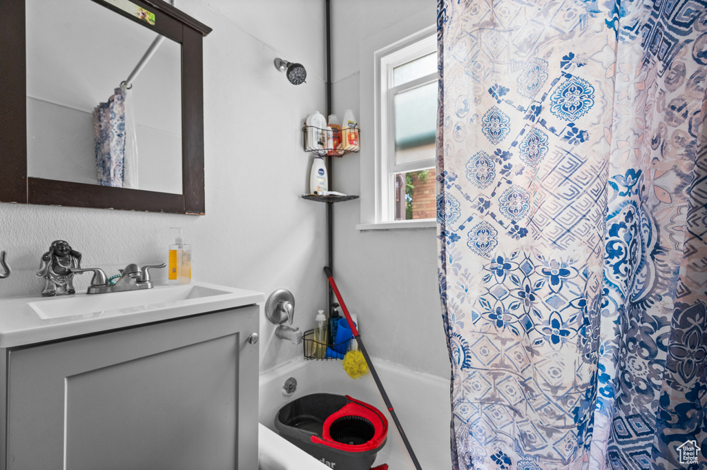 Full bath with vanity, curtained shower, and a bathtub