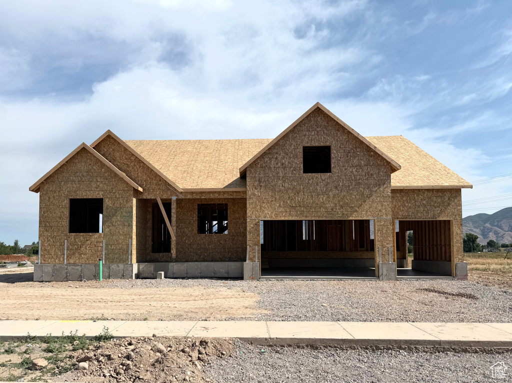 Property in mid-construction with a garage, driveway, and a shingled roof