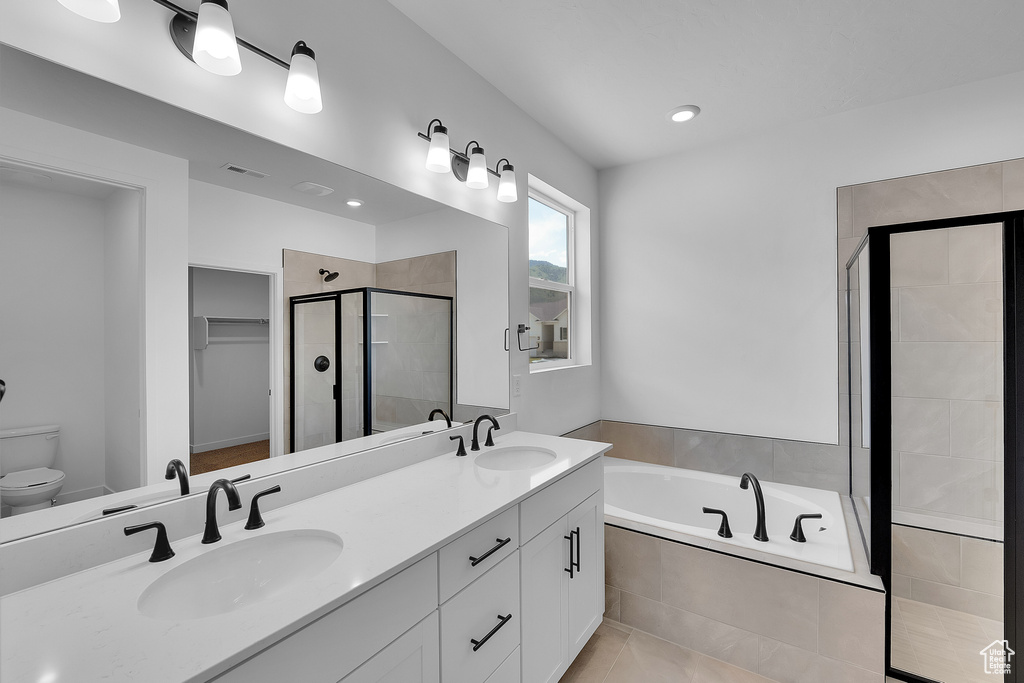 Full bathroom featuring a shower stall, double vanity, a garden tub, a walk in closet, and tile patterned flooring