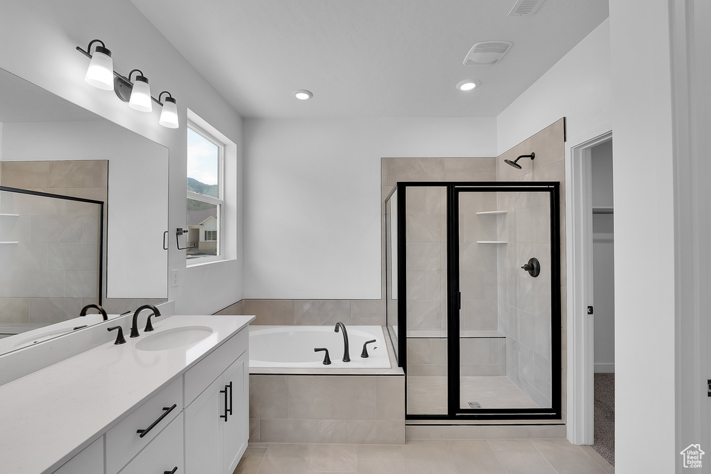 Full bath with a stall shower, a bath, vanity, a spacious closet, and recessed lighting