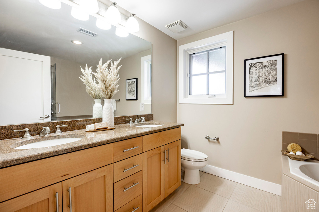 Full bathroom featuring double vanity, a bath, and tile patterned floors